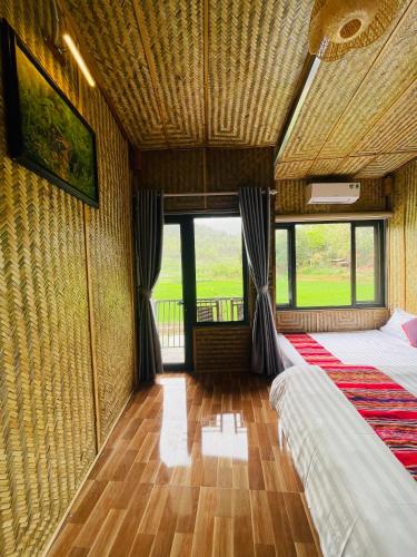 a room with two beds and a large window at Quế Homestay in Hòa Bình