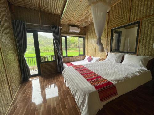 a bedroom with a large bed and a large window at Quế Homestay in Hòa Bình