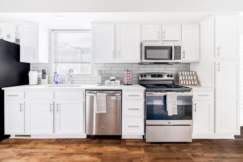 a white kitchen with a stove and a microwave at Luxury Downtown Townhome Private Garage Unit 4 in Cleveland