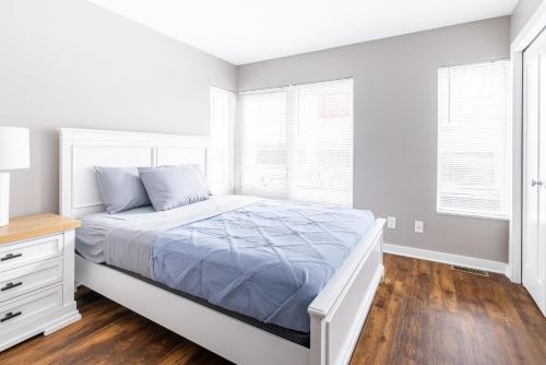 a white bedroom with a bed and windows at Luxury Downtown Townhome Private Garage Unit 11 in Cleveland