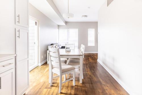a white dining room with a white table and chairs at Luxury Downtown Townhome Private Garage Unit 10 in Cleveland
