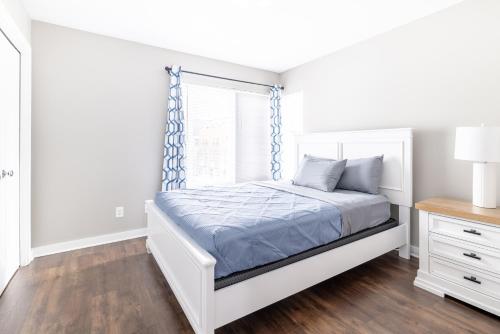 a white bedroom with a bed and a window at Luxury Downtown Townhome Private Garage Unit 10 in Cleveland