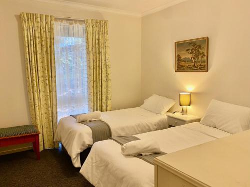 a hotel room with two beds and a window at Aalen in Jindabyne