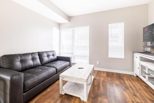 a living room with a leather couch and a coffee table at Luxury Downtown Townhome Private Garage Unit 10 in Cleveland