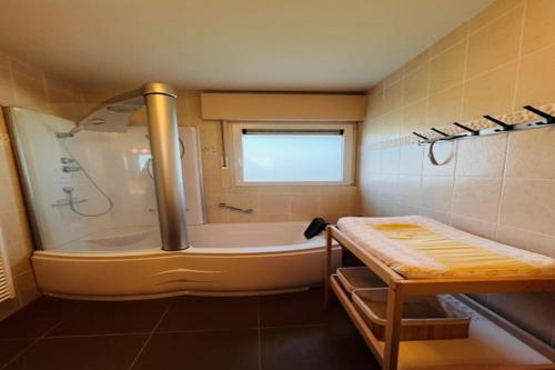 a bathroom with a tub and a shower with a window at Holiday Home in Wenduine near Zeedijk in Wenduine