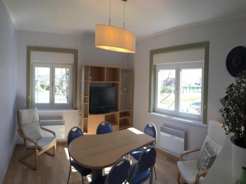 a living room with a table and chairs and a television at Apartment near Zeedijk Beach Promenade in Wenduine