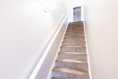 a stairway in a white building with a door and stairs at Luxury Downtown Townhome Private Garage Unit 10 in Cleveland