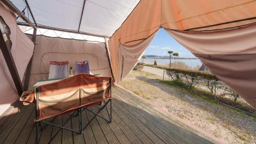 a tent with a table and a chair inside at Taean Bibi ArtGlamping in Taean