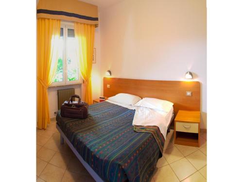 ピエトラ・リーグレにあるClassic Appartement in Pietra Ligureのホテルルーム ベッド1台 スーツケース付