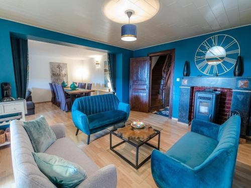 a living room with blue walls and a clock on the wall at Country House near Coo Waterfalls with Jacuzzi in Stoumont