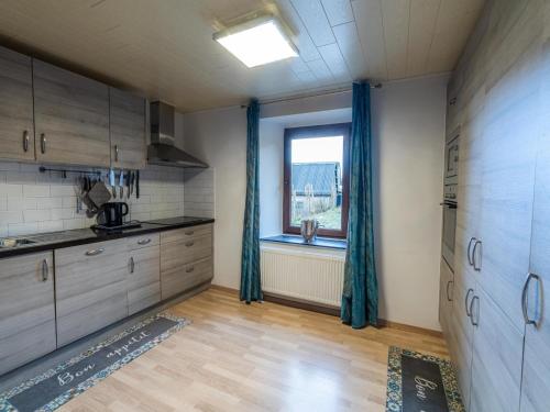 a kitchen with wooden floors and a window in a room at Country House near Coo Waterfalls with Jacuzzi in Stoumont