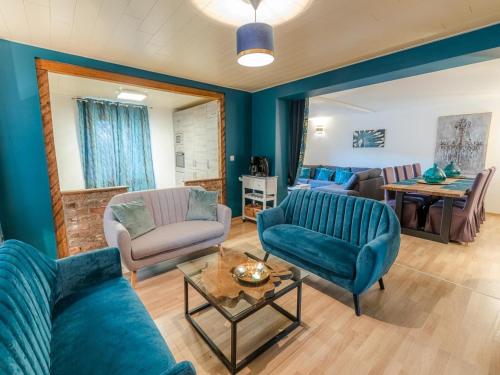 a living room with blue walls and blue furniture at Country House near Coo Waterfalls with Jacuzzi in Stoumont