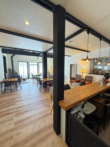 a living room and dining room with tables and chairs at The Bunkhouse Hakuba by Mr T in Hakuba