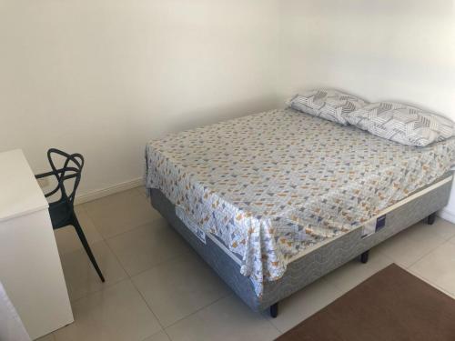 パリョサにあるQuarto Essencial com Conforto em casa compartilhadaの黒い椅子付きの客室の小さなベッド1台分です。