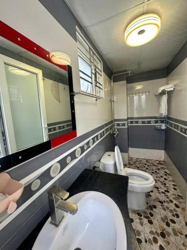 a bathroom with a sink and a toilet and a mirror at Ớt Family - 128 Cái Bèo - Homestay Cat Ba in Cat Ba