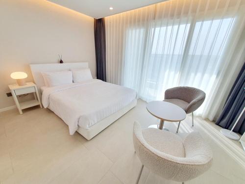 a bedroom with a bed and a table and chairs at Le Bleu Naksan by Orot in Yangyang