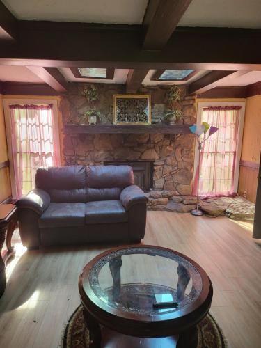 a living room with a couch and a stone fireplace at Spacious ranch home near Stone Mountain Park in Stone Mountain