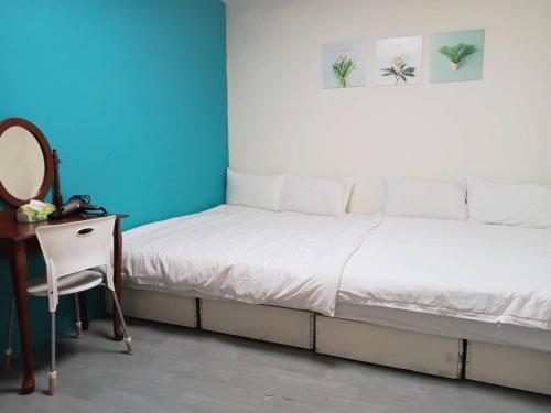 a bedroom with a bed and a desk and a mirror at 日月潭水里東方海悅輕旅包棟 in Shuili