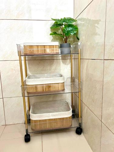 a towel rack with three baskets and a plant at Dauis Panglao Staycation in Dauis
