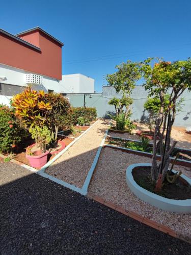 a garden with trees and plants in front of a building at Quarto Califórnia in Campo Novo do Parecis
