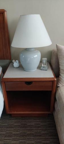 a lamp on a table next to a couch at Confortable apartamento en La Carolina in Quito