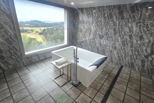 a bathroom with a sink and a large window at 강진 다산베아채 골프앤리조트 호텔형 in Songhak
