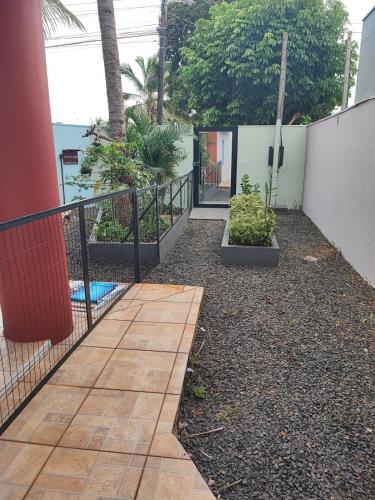 a patio with a fence and some plants at Quarto Califórnia in Campo Novo do Parecis