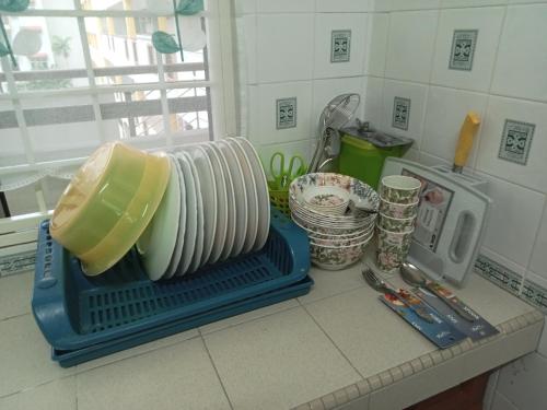 a stack of plates sitting on a counter in a kitchen at Couple place in Port Dickson
