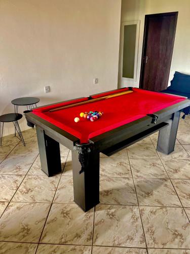 a red pool table in a room with two tables at Casa da Lagoa in Tramandaí