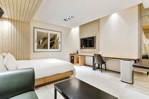 a hotel room with a bed and a desk at 포항 에이원 호텔 죽도 Pohang A1 Jukdo in Pohang