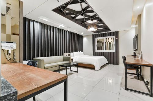 a living room with a bed and a couch at 포항 에이원 호텔 죽도 Pohang A1 Jukdo in Pohang