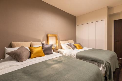 two beds sitting next to each other in a room at Rizo Zaizen Hotel in Ginowan