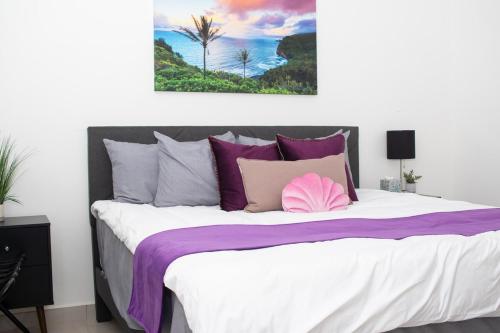 Un dormitorio con una cama grande con almohadas moradas. en Good Life Casita at Rocky Point, en Puerto Peñasco