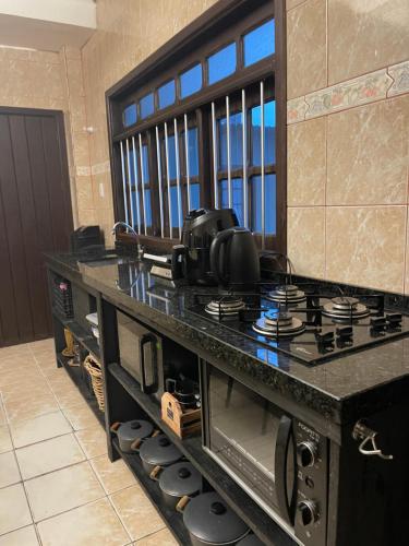 a kitchen with a counter with a stove top oven at Casa da Lagoa in Tramandaí