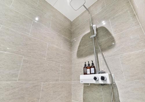 a bathroom with a shower with bottles of wine at 포항 에이원 호텔 죽도 Pohang A1 Jukdo in Pohang
