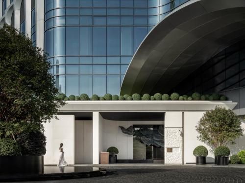a woman walks in front of a building at HUALUXE Shenzhen Bao'an in Shenzhen