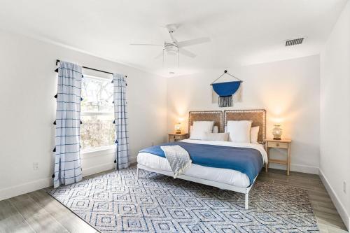 a bedroom with a blue and white bed and a window at The Jungle House - Brand New 32 Close To Dt! in West Palm Beach