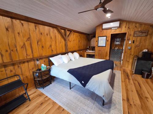 罗宾斯维尔Lazy T Cabins - Acadia的一间带床的卧室，位于一间带木墙的房间里