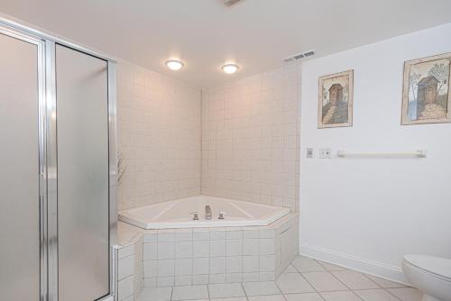 a white bathroom with a tub and a toilet at Spacious 3-Bedroom Condo at Sunset Bay Perfect for Families in Ocean City in Ocean City