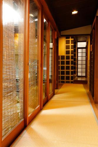 a corridor of a building with glass doors at Yoshii Ryokan in Kurashiki