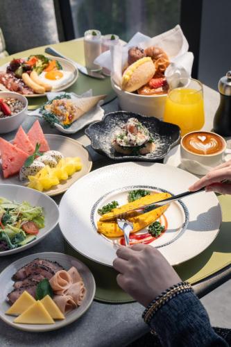 a table with plates of food on it at HUALUXE Shenzhen Bao'an in Shenzhen