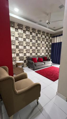 a living room with two couches and a red rug at Md homestay in Kampong Kubang Menderong