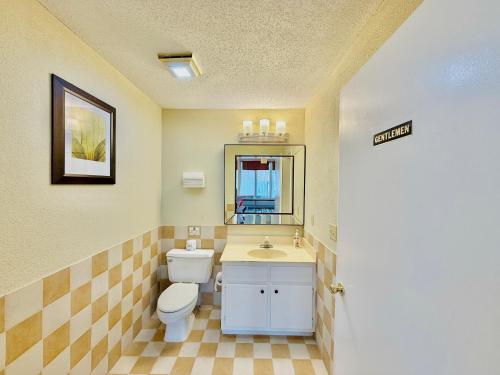 a bathroom with a toilet and a sink and a mirror at Travelodge by Wyndham-Thomasville AL in Thomasville