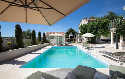 a swimming pool with chairs and an umbrella at Villa Stanza in Rovinj