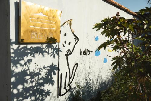 a sign on a wall with graffiti on it at The White Courtyard in Dali