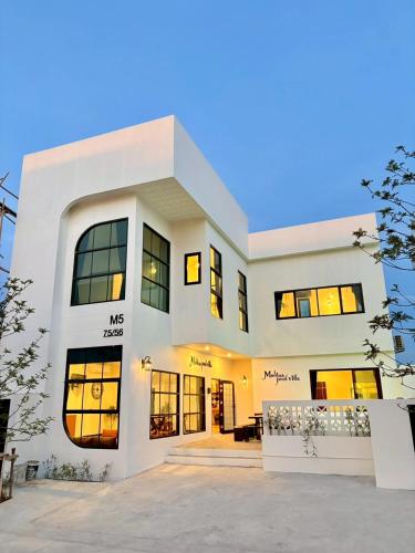a large white house with a lot of windows at Medina Private Pool Villa-บางแสน in Ban Puk (1)