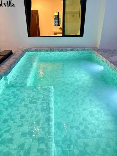 a large swimming pool with a mirror in a room at Medina Private Pool Villa-บางแสน in Ban Puk (1)