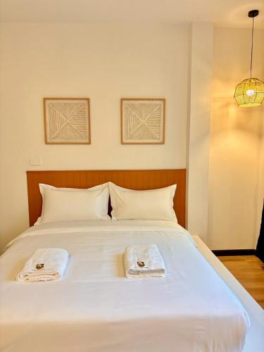 a large white bed with two towels on it at Medina Private Pool Villa-บางแสน in Ban Puk (1)