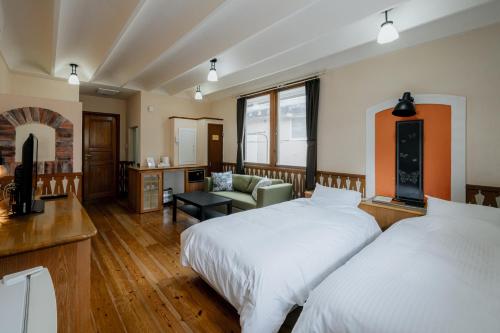 a bedroom with two beds and a living room at Coast Villa DAISEN in Daisen