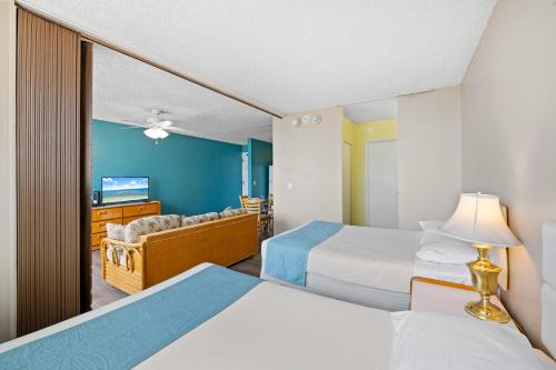 a hotel room with two beds and a mirror at Royal Kuhio 2309 - Spacious Studio with Stunning Ocean Views in the Heart of Waikiki! in Honolulu